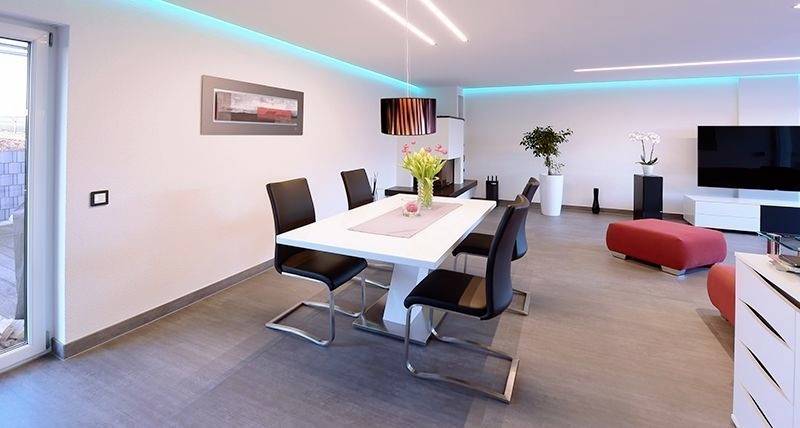 Modernes Wohnzimmer mit Esstisch und vier schwarzen Stühlen, blauer LED-Beleuchtung, Bild an der Wand, TV und roten Hockern.