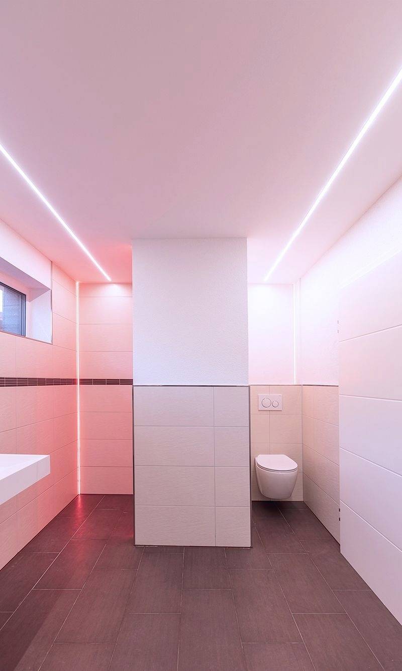 Ein modernes Badezimmer mit minimalistischem Design. Helle Fliesen, schwebendes WC und dezente Beleuchtung schaffen eine ruhige Atmosphäre.