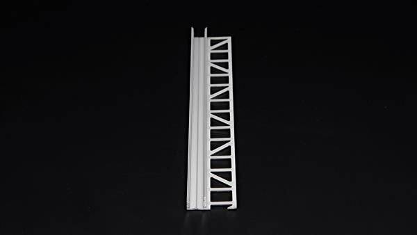 Ein weißes Deckprofil mit einem gerasterten Design liegt auf einer schwarzen Oberfläche. Das Profil hat eine rechteckige Form.