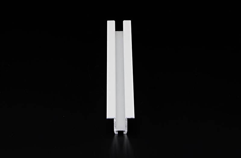 Ein weißes, rechteckiges Aluminiumprofil, aufrecht stehend, vor einem schwarzen Hintergrund.