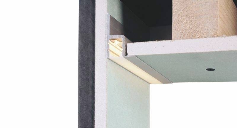 Ein Querschnitt einer Wand mit Holzverkleidung und integrierter LED-Beleuchtung unten, zeigt Aufbau und Beleuchtungstechnik.