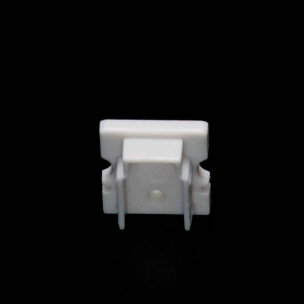 Ein weißer Plastikclip steht aufrecht vor schwarzem Hintergrund.