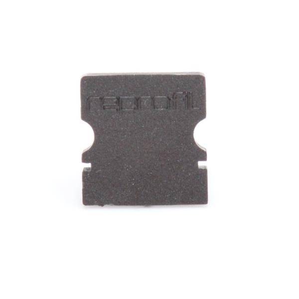 Ein kleines, dunkelbraunes, quadratisches Objekt mit abgerundeten Ecken und einer eingeprägten Schrift.