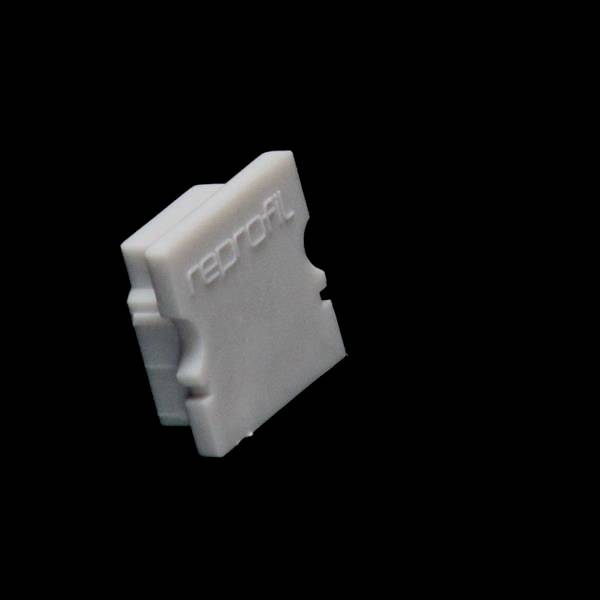 Ein weißes rechteckiges Objekt mit der Aufschrift 'reprofil' steht aufrecht auf schwarzem Hintergrund.