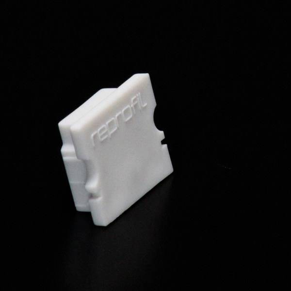 Ein weißes, rechteckiges Kunststoffteil mit der Aufschrift 'reprofil' auf schwarzem Hintergrund.