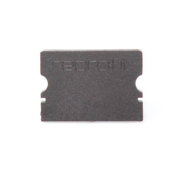 Schwarze Rasierklinge mit abgeschrägten Kanten vor weißem Hintergrund; eingravierte Schrift schwer lesbar.