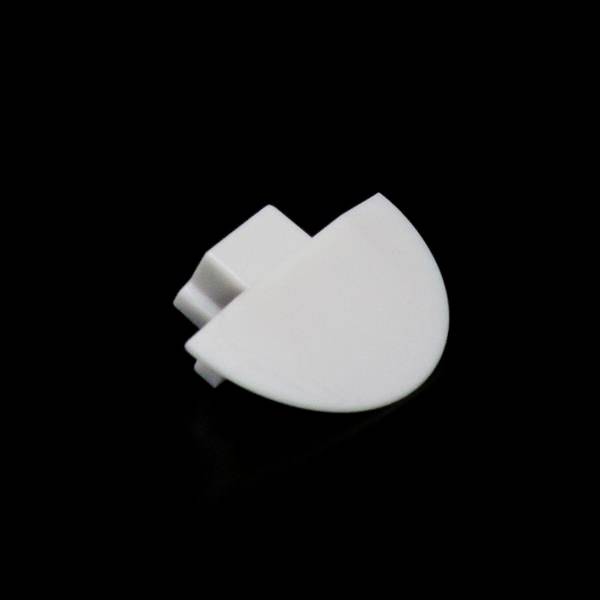 Ein einzelnes weißes LEGO-Teil, halbkreisförmig mit einem Zylinderstift auf einer Seite, vor schwarzem Hintergrund.