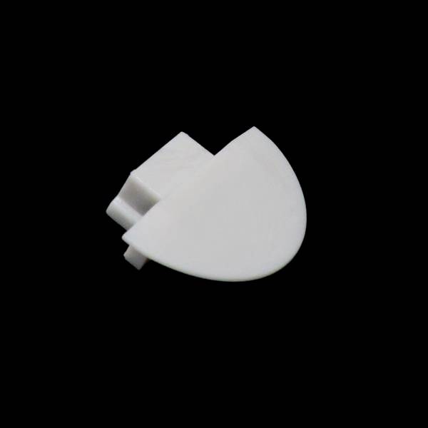 Ein weißes, halbkreisförmiges Objekt aus Kunststoff, mit einer flachen und einer runden Seite, vor einem schwarzen Hintergrund.