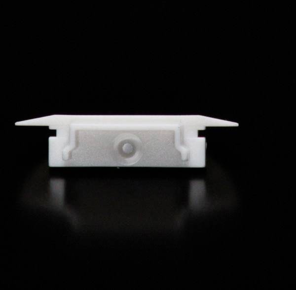 Kunststoffbauteil vor schwarzem Hintergrund, rechteckige Form, unteres Profil sichtbar, Darstellung eines technischen Objekts.