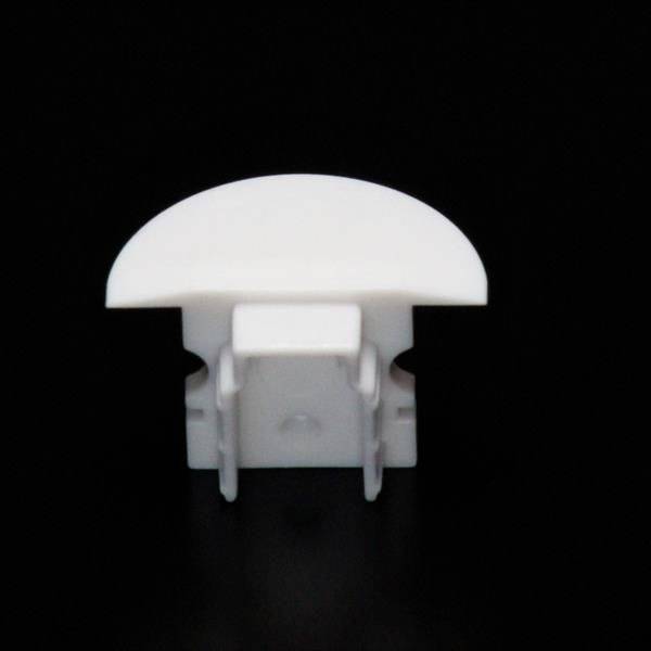 Ein weißes, halbrundes Kunststoffteil vor einem schwarzen Hintergrund.