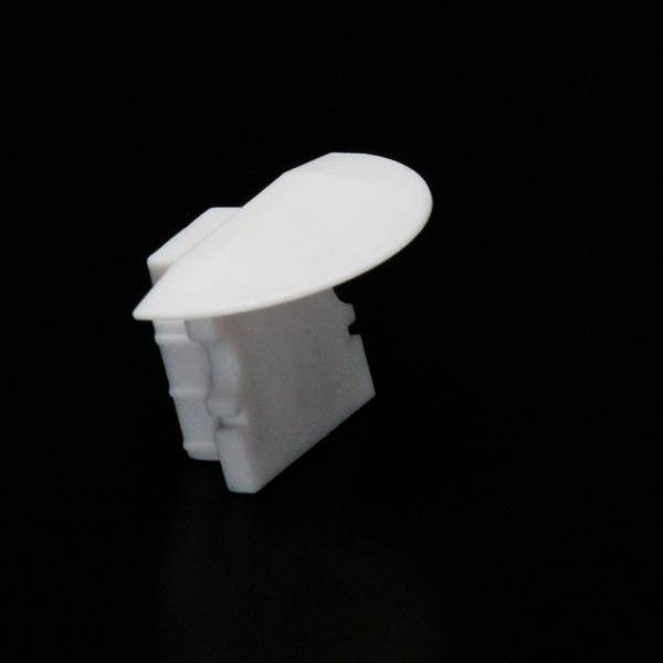 Ein weißes, dreidimensionales Objekt mit runder Oberseite auf schwarzem Hintergrund. Form erinnert an ein Architekturmodell.