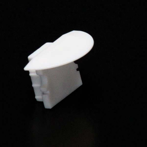 Weiße, abgerundete Kunststoff-Eckabdeckung vor schwarzem Hintergrund.