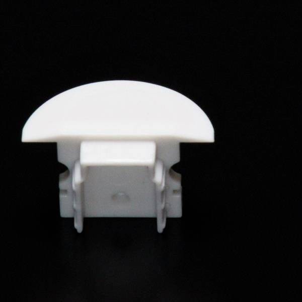 Ein weißer, abgerundeter Kunststoffclip vor schwarzem Hintergrund, vermutlich für Kabel- oder Papierbefestigung geeignet.