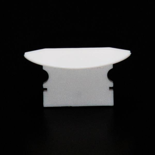 Ein weißes, rechteckiges Plastikobjekt mit zwei Einfassungen, vor einem schwarzen Hintergrund.