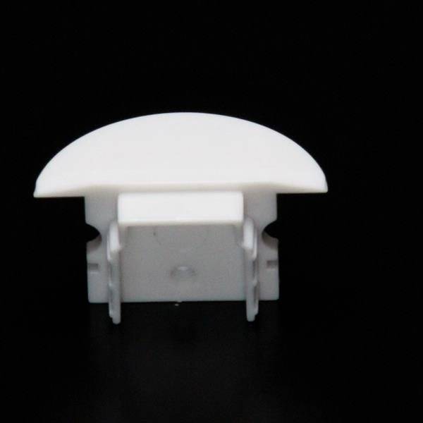 Weiße Kunststoffabdeckung auf schwarzem Hintergrund, vermutlich für den Schutz oder die Abdeckung eines technischen Elements.