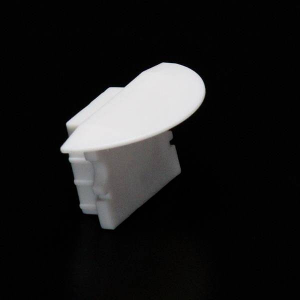 Weiße, abgerundete Kunststoffabdeckung vor schwarzem Hintergrund, möglicherweise für den Schutz von elektrischen Steckdosen konzipiert.