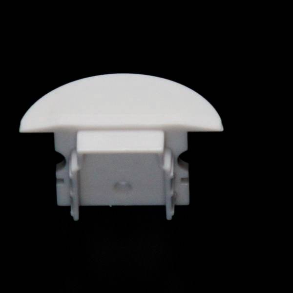 Ein weißes, halbrundes Kunststoffobjekt auf schwarzem Hintergrund, vermutlich ein Steckdosenabdeckungsstück oder eine Gehäuseteil.