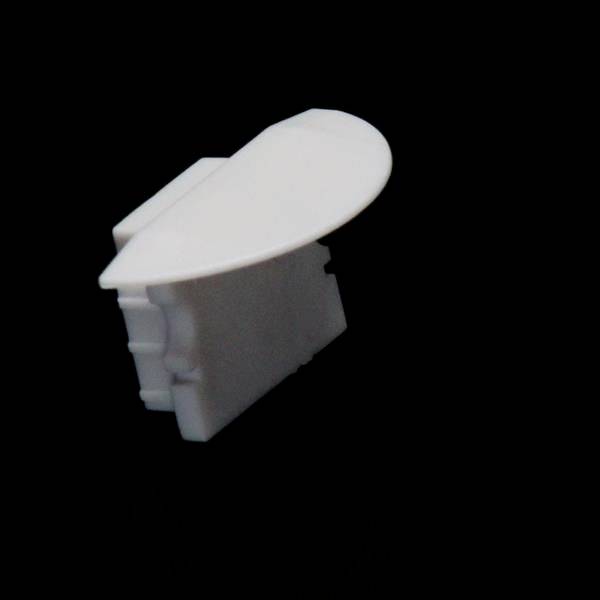 Ein ovales, weißes Plastikstück vor schwarzem Hintergrund. Möglicherweise ein technisches Bauteil oder eine Abdeckung.