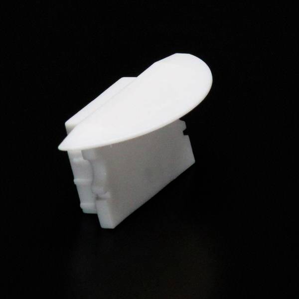 Weiße Plastik-Klemme vor schwarzem Hintergrund.