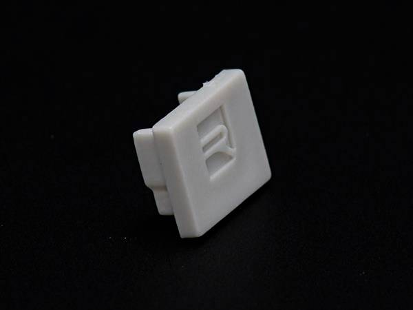 Weiße Computertaste mit 'R'-Aufschrift auf schwarzem Hintergrund.