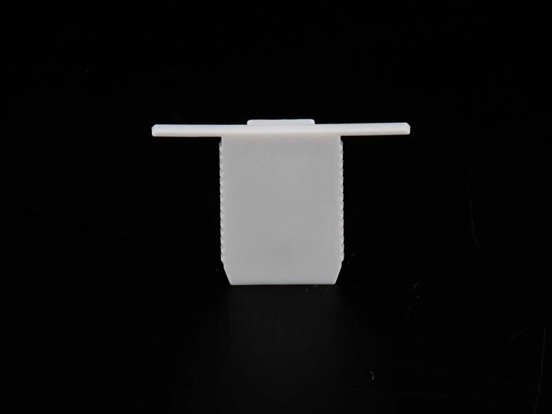 Weiße, rechteckige Kunststoffbefestigung mit flachem Kopf gegen schwarzen Hintergrund. Oft zur Kabelorganisation verwendet.