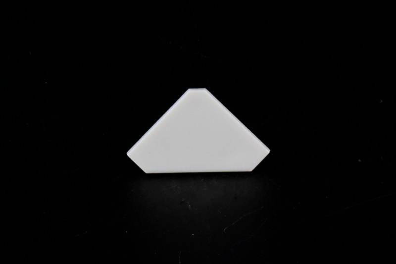 Weiße, dreieckige Kachel mit dunklem Hintergrund.