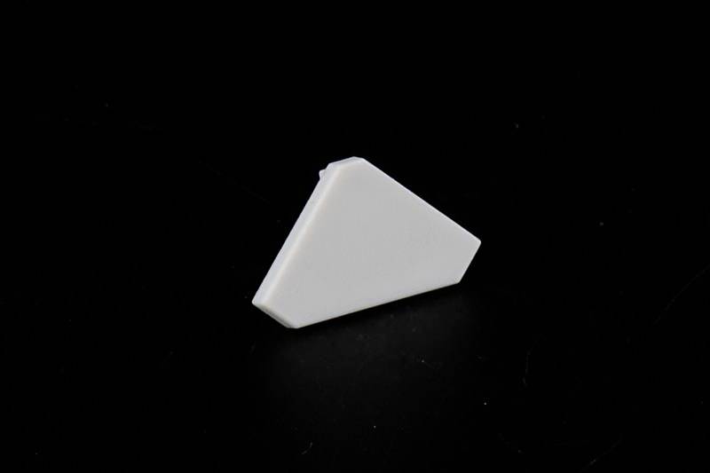 Ein weißer, dreieckiger Gegenstand liegt auf einem schwarzen Hintergrund.