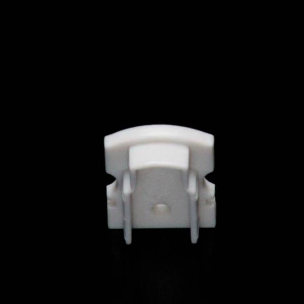 Weißes, plastisches Objekt auf schwarzem Hintergrund, möglicherweise ein Teil eines größeren Geräts oder Zubehörs.