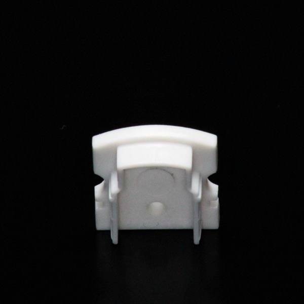 Ein weißer, rechteckiger Kunststoffclip vor schwarzem Hintergrund. Geeignet zur Befestigung von Kabeln oder dünnen Objekten.