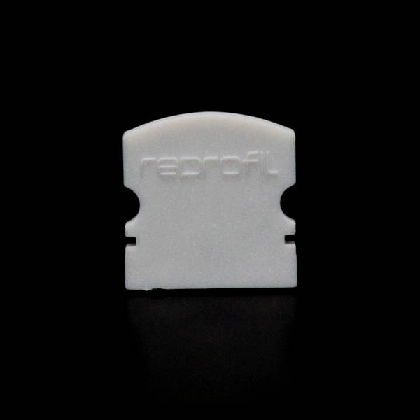 Ein weißes Plastikobjekt mit der Aufschrift 'reprofil' vor einem schwarzen Hintergrund. Das Objekt hat geschwungene Kanten.