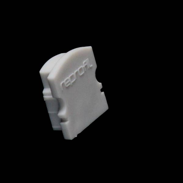 Ein weißer, gebogener Gegenstand mit der Aufschrift 'reprofil'. Der Gegenstand hat keine erkennbare Funktion auf dem Bild.