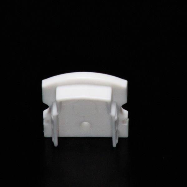 weißer Plastikclip vor schwarzem Hintergrund, vermutlich ein Kabelhalter oder Ähnliches, von vorne gesehen.