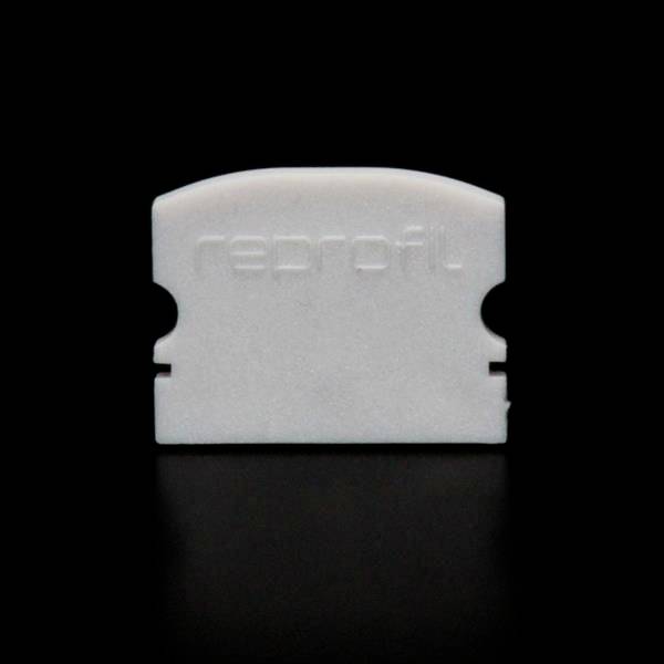 Ein weißes Kunststoffobjekt mit der Prägung 'reprofil' auf einer schwarzen Oberfläche.