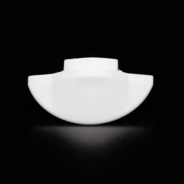 Ein weißes Kunststoffobjekt mit runder Form und geriffeltem Rand, vor schwarzem Hintergrund.