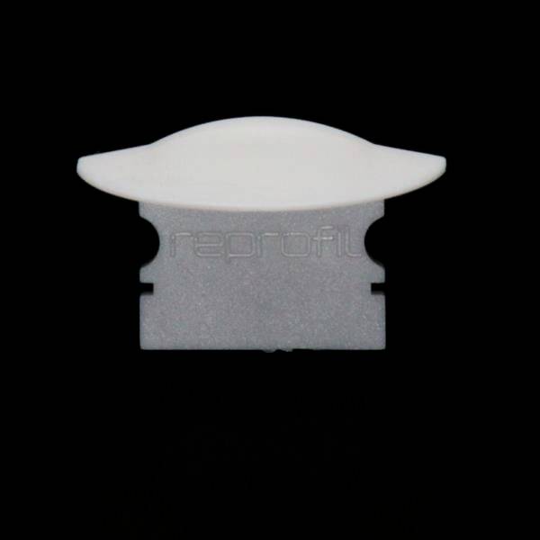 Ein weiß-graues Kunststoffteil, möglicherweise ein Verbindungsstück oder eine Klemme, vor schwarzem Hintergrund.