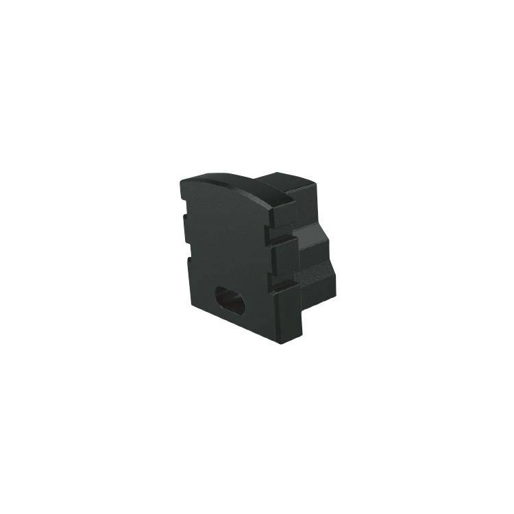 Schwarzes, rechteckiges Bauteil mit mehreren Stufen und einem ovalen Loch an der unteren Ecke, möglicherweise ein technisches Element.