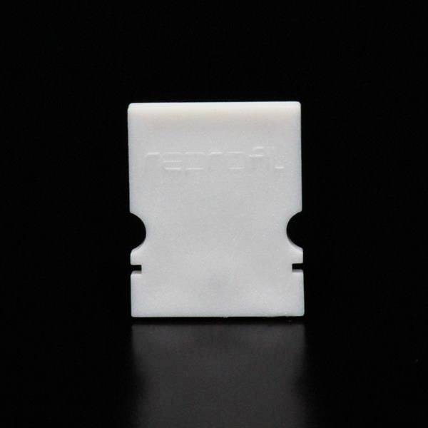 Ein weißes, rechteckiges Plastikteil mit der Prägung 'reprofit' auf schwarzem Hintergrund.