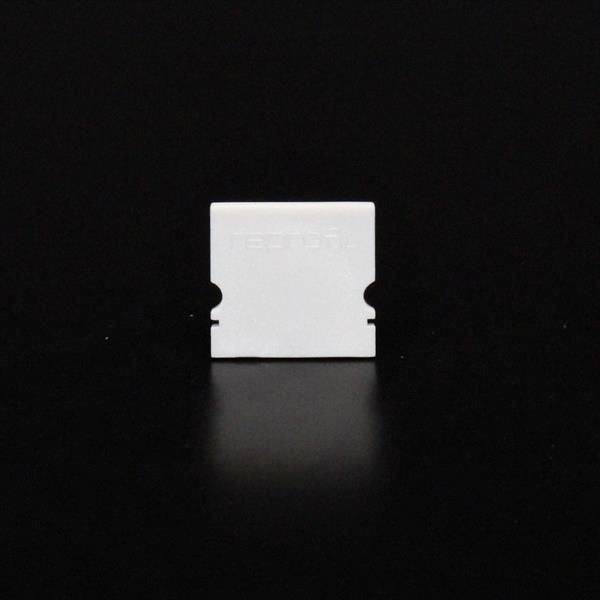 Eine weiße Rasierklinge auf schwarzem Hintergrund.