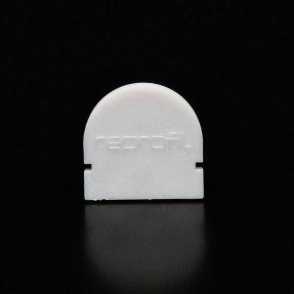 Eine weiße Kunststoffform mit dem Schriftzug 'reprofi.' steht vor einem schwarzen Hintergrund.