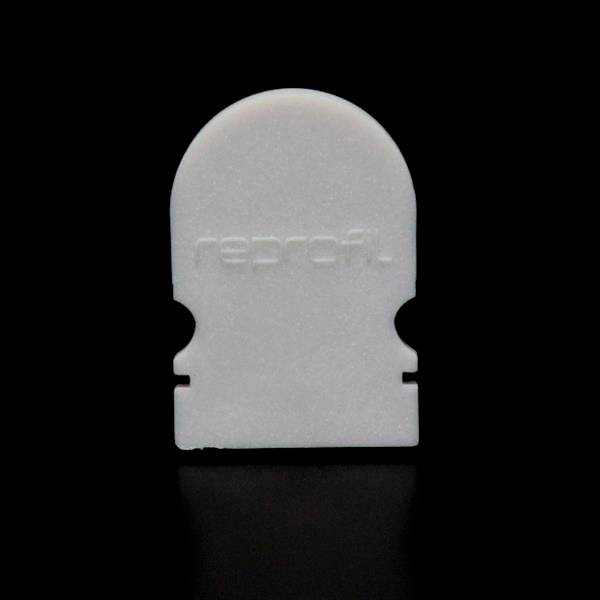 Weiße, hausförmige Kunststoffscheibe auf schwarzem Hintergrund, mit der Aufschrift 'reprofil'.
