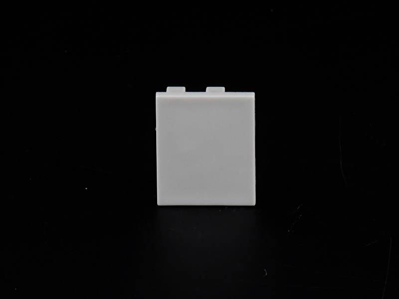 Ein weißer, quadratischer Plastikwürfel steht vor schwarzem Hintergrund.