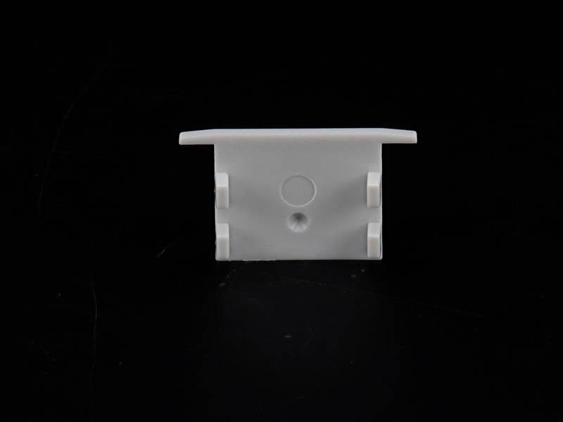 Weiße Kunststoffhalterung mit rechteckiger Form, zwei seitlichen Clips und einem mittigen Loch auf schwarzem Hintergrund.