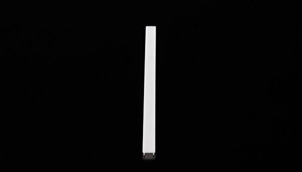 Ein weißer, langer, rechteckiger Stab liegt vertikal auf schwarzem Hintergrund.