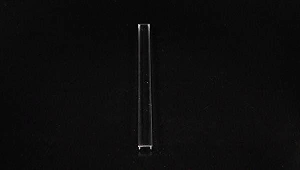 Ein einzelnes durchsichtiges Reagenzglas liegt auf einem schwarzen Hintergrund.