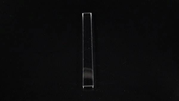 Eine transparente, rechteckige Kunststoffleiste vor einem schwarzen Hintergrund.