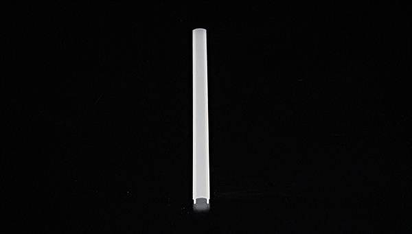 Ein einzelnes weißes Objekt steht vertikal auf schwarzem Hintergrund, schlicht und minimalistisch dargestellt.