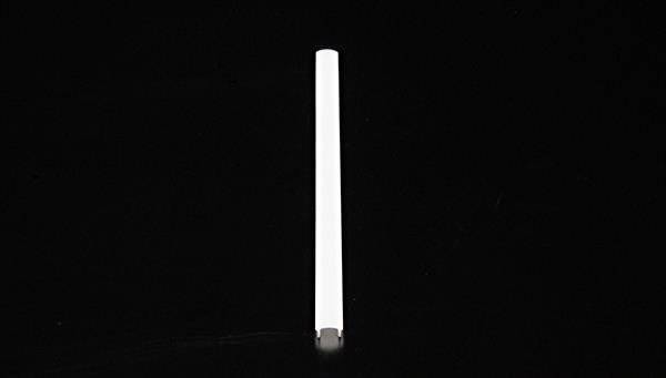 Ein dünner, weißer, vertikaler Zylinder auf schwarzem Hintergrund.