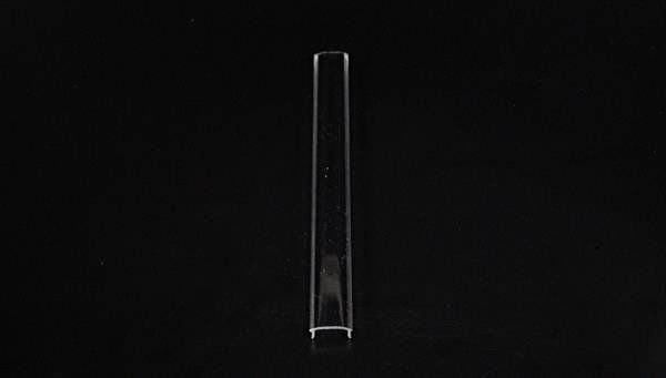 Ein transparentes, leeres Reagenzglas liegt vertikal auf schwarzem Hintergrund.