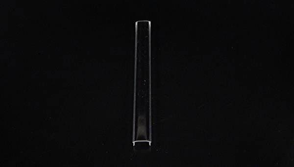 Ein transparentes, vertikales Glasrohr vor einem schwarzen Hintergrund.