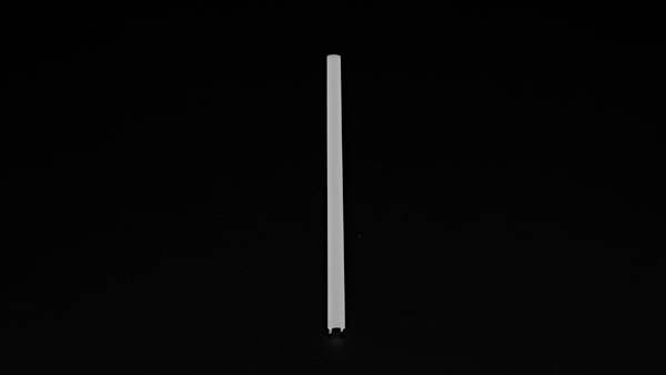 Ein einzelner weißer Stab steht vertikal auf schwarzem Hintergrund.